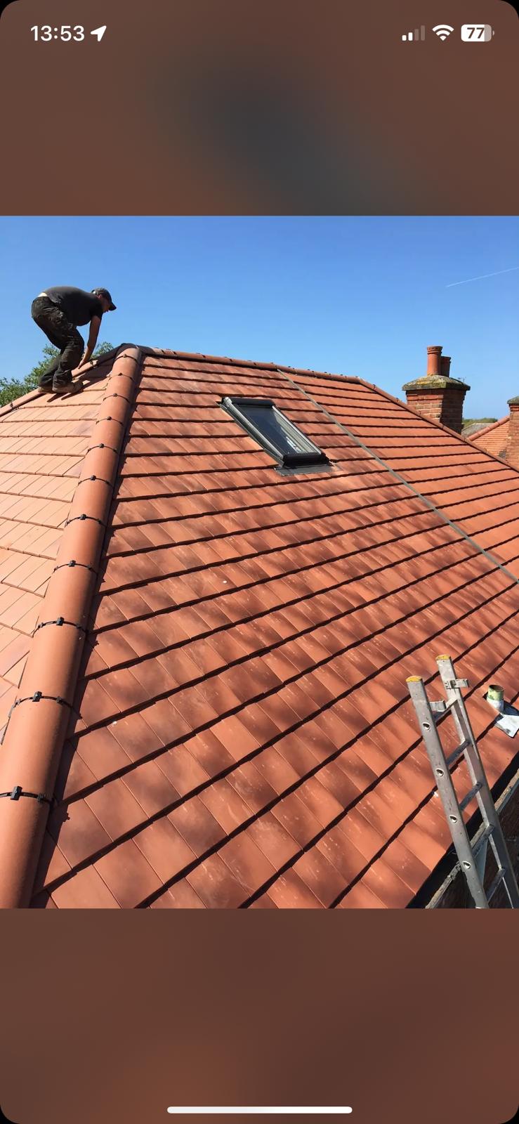 Completed full roof installation with terracotta plain tiles, Velux window and hip tiles