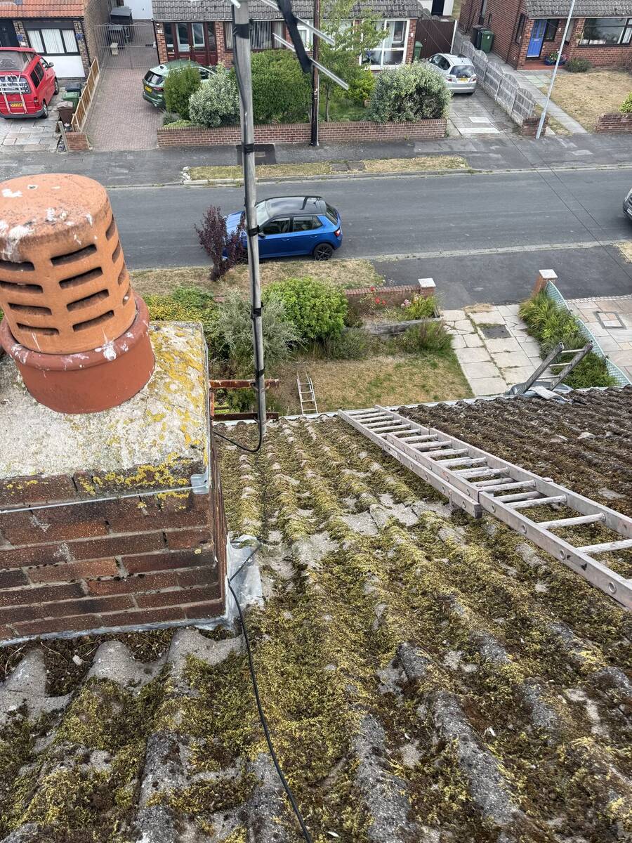 Chimney flashing cleared of moss during a Crosby roof job