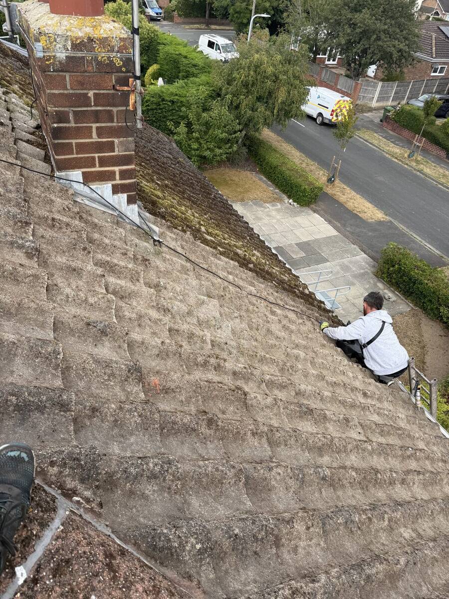 Moss-covered pitched roof in Crosby before hand removal